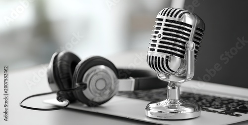 Obraz na płótnie Vintage-style silver microphone with black headphones on a white surface