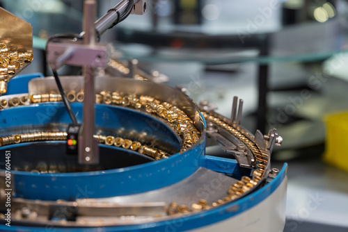 Φωτογραφία Vibratory bowl feeder conveying small metal hardware parts production scene