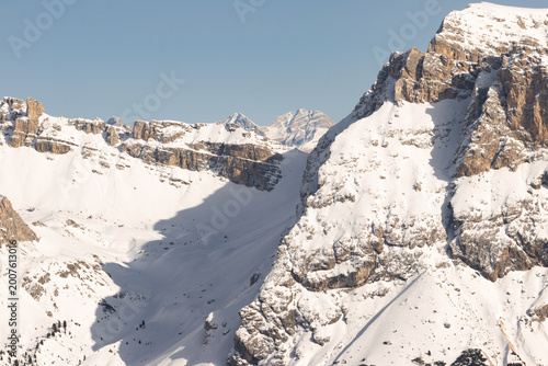 Foto Steep snowy basin beneath rugged mountain walls