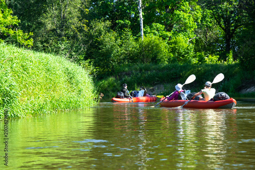 Group paddling inflatable kayaks down scenic river, outdoor water sport, summer adventure, family rafting, tourism and recreation use.