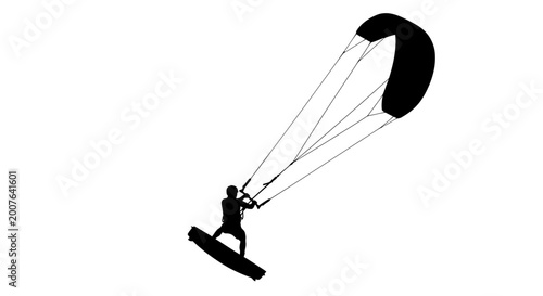 Silhouette of a kiteboarder surfing with a large kite