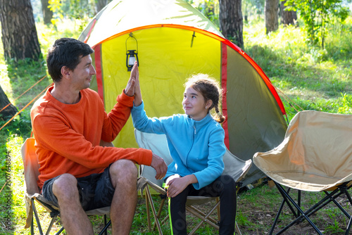 Foto Father and daughter at tent, outdoor family camping, comfort in sporty clothes, exploring nature, picnic and leisure