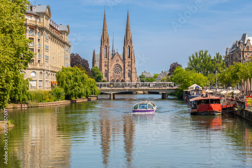 Canvas-taulu l'Église Saint-Paul de Strasbourg avec un Bateau promenade en avant plan
