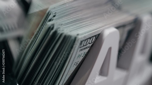 Fast counting of dollar banknotes in automatic machine with focus on movement. Concept financial turnover and liquidity.
