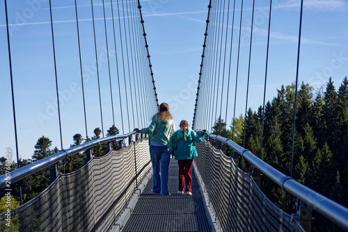 Mother and Daughter Walking Together on the Wildline Suspension Bridge in the Black Forest