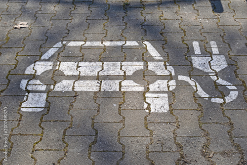 Vehicle Charging Sign Painted on Concrete Pavers in Street