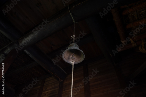 Tableau sur toile Antique Bronze Bell Hanging from a Dark Wooden Beam in a Traditional Japanese Ho