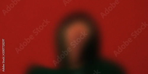 Bild auf Leinwand Blurred silhouette of a person standing against a red background with noticeable grainy texture, creating a mysterious mood