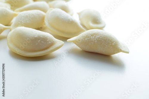 Raw dumplings on a white background. Frozen raw dumplings with ice crystals on a white background