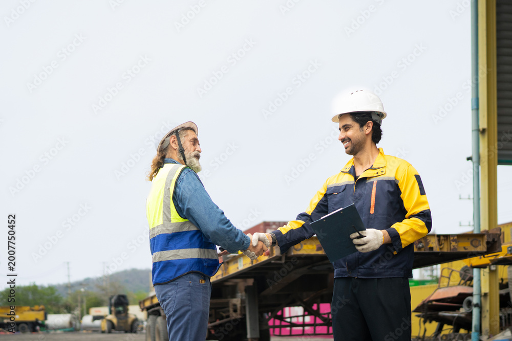 Fototapeta premium Engineer and worker feel happy when they achieve their goals, They shouted and shake hands with joy at containers cargo site, Success and teamwork concepts
