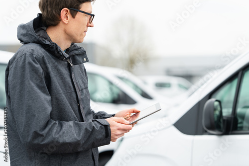 Εκτύπωση καμβά Fleet manager with digital tablet supervising rows of white delivery vans