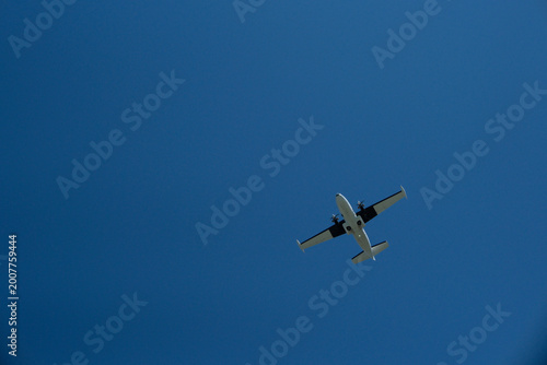 Photos Low Angle View of a Twin-Engine Propeller Plane Flying in Clear Blue Sky on Sunn