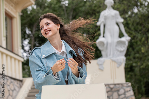 Portrait of a young beautiful brunette woman in a blue leather jacket