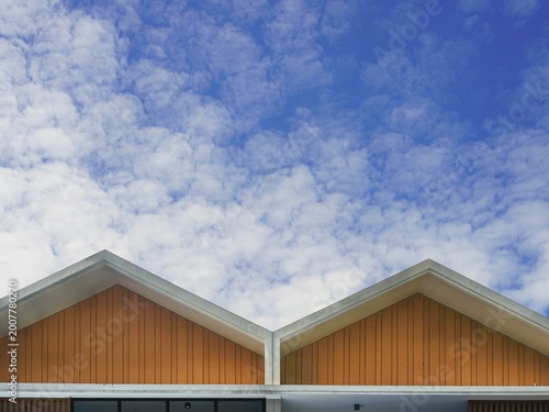 Photos Symmetrical wooden gabled rooftops against a dramatic blue cloudy sky