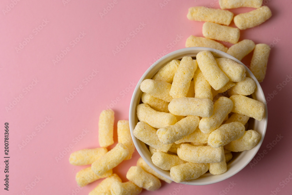 Obraz premium Crunchy Corn Puffs Closeup. Playfully Scattered Puffed Corn Pieces On Vibrant Surface For Advertisement