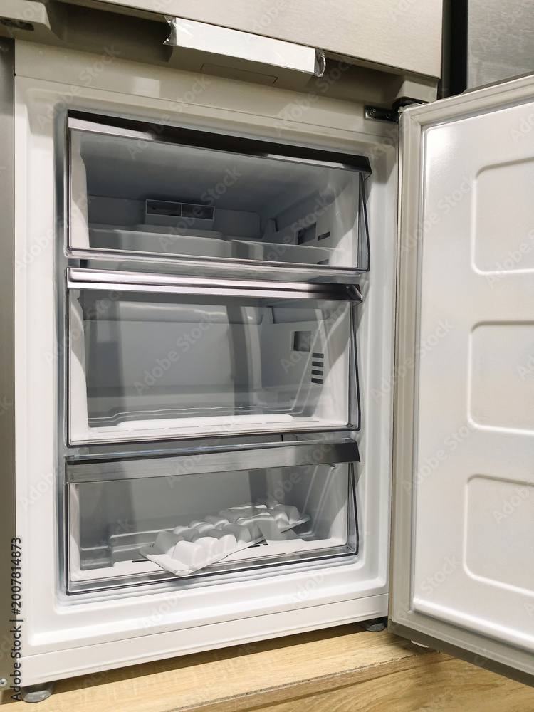 Fototapeta premium Large fridge with open freezer door, now available in a major supermarket