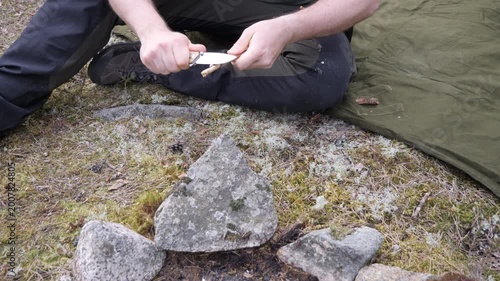 Camper Whittling a Wooden Stick with Knife Outdoors