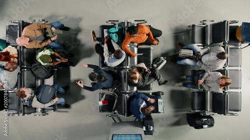 Checking visa documents, talking and people in airport hub, top down view. Checking plane tickets, devices and travelers having conversations during flight layover, high angle shot