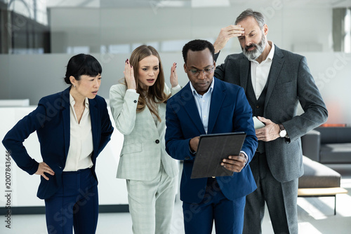Bild auf Leinwand Diverse business team suffering from stress and frustration while looking at a t