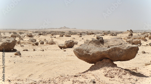Photos Wide desert landscape near Duqm, Oman, featuring a mushroom‑shaped rock formation sculpted by wind and sand erosion in the arid Al Wusta region