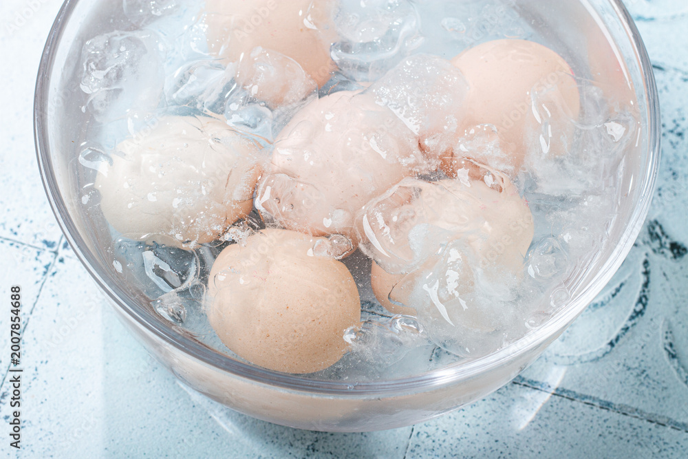 Fototapeta premium Boiled eggs in a glass bowl, with ice, product cooling, no people,