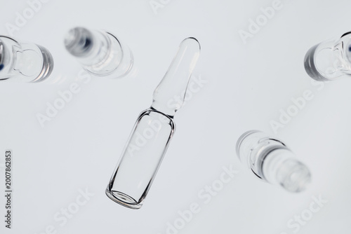 Glass ampoules floating, symbolizing pharmaceutical development, vaccination and medicine