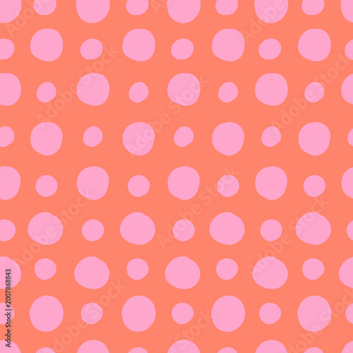 Pink polka dots on red background seamless pattern. Large and small hand-drawn circles. Cute pattern. Abstract vector background.
