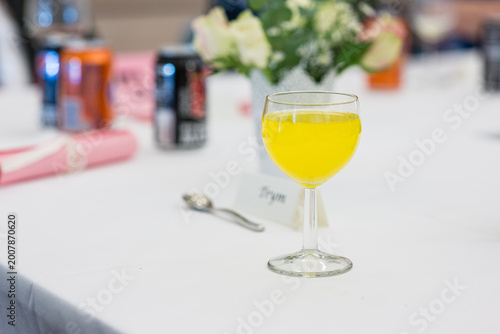 фотографія Yellow drink in wine glass on decorated event table indoors.