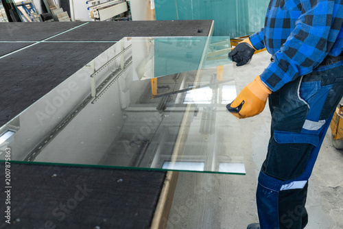 Schilderij op canvas The glassmaker in the workshop holds a large piece of glass in his hands