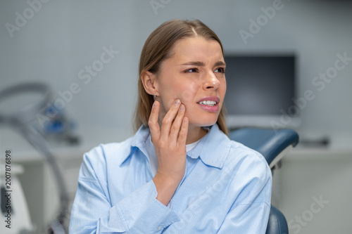 Woman suffering from toothache in dental clinic
