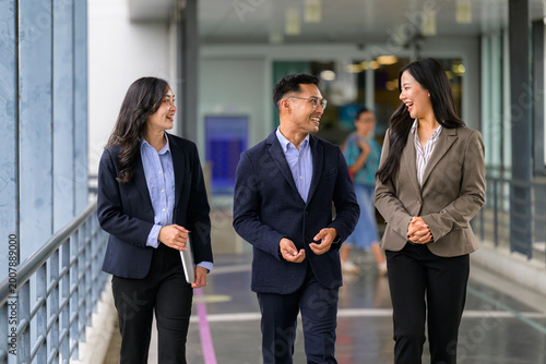 Asian business professionals walking discussing during work