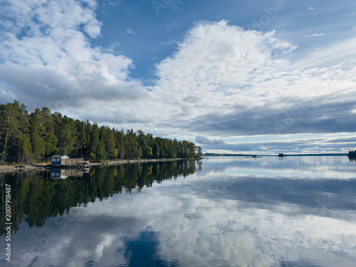 Bild auf Leinwand Swedish lake landscape with a boathouse and reflections
