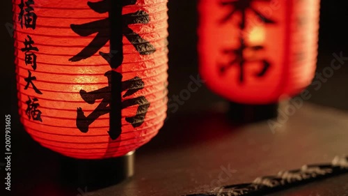 Traditional red Japanese paper lanterns glowing warmly at night, detailed calligraphy, ambient atmosphere, cultural decor