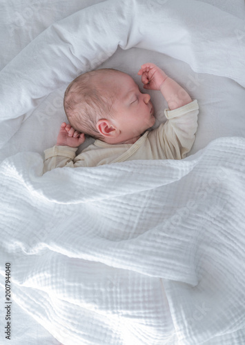 Fotografía Newborn baby sleeping peacefully on white bed