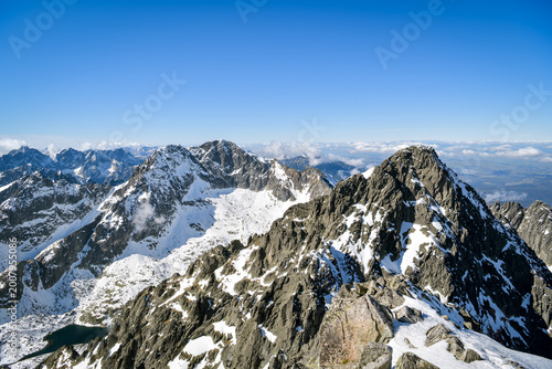 Snow-dusted rocky ridges of high alpine summit