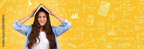 Foto A student struggles with math while holding a book on her head