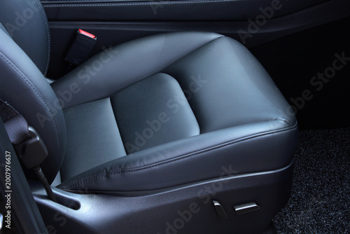Driver seat of a new modern car. Leather car interior. Black leather drivers seat in a car. Sleek black automotive seat crafted from smooth leather material with visible stitching. Its contoured shape