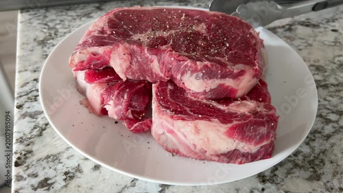 Raw Steaks Arranged on Marble Countertop