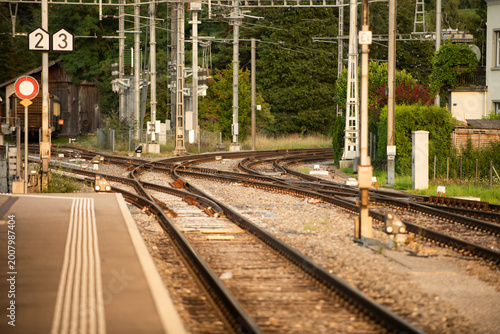 Schilderij op canvas Train rail tracks at railway station platform