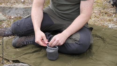 Hiker Sitting on Outdoor Mat with Compact Camping Gear