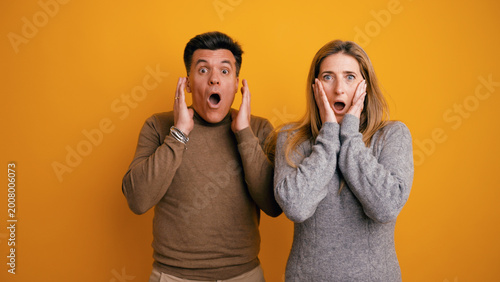 Tableau sur toile People gasping with wide eyes and open mouths, holding hands to their faces, sho