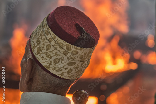 Hand holding traditional staff near fire during Samaritan Passover ritual