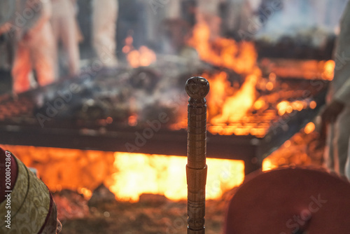 Hand holding traditional staff near fire during Samaritan Passover ritual