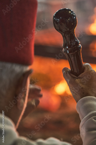 Hand holding traditional staff near fire during Samaritan Passover ritual