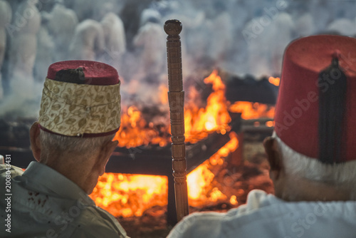 Hand holding traditional staff near fire during Samaritan Passover ritual