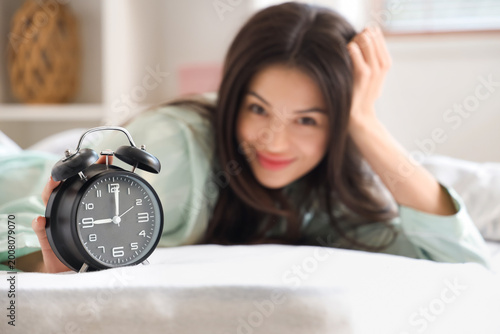 Young woman with alarm cloc...