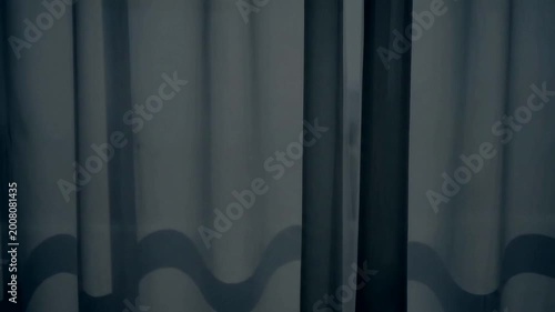 Abstract background of gray wavy fabric curtains in a dimly lit room.