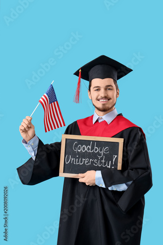 Male graduate student holding chalkboard with text GOODBYE UNIVERSITY and fla...