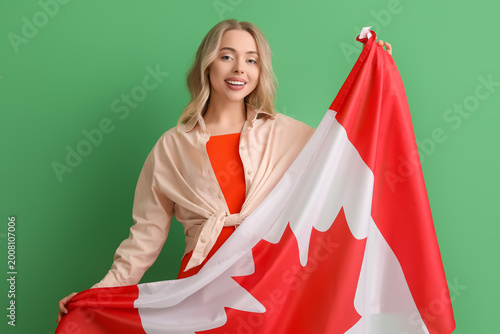 Young woman with flag of Canada on green background