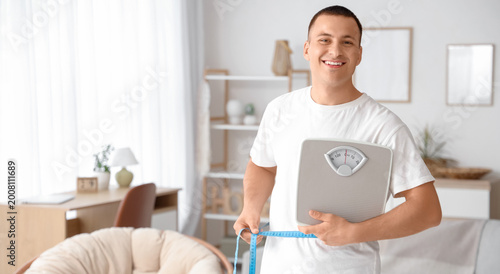Young man with weight scale...